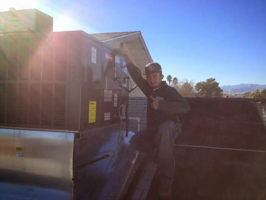 HVAC technician performing AC Tune-Up on a rooftop unit in Lewisburg