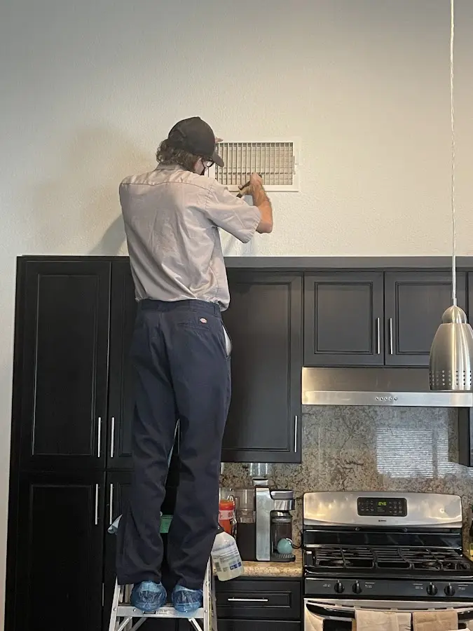 Technician inspecting an air vent during HVAC service in Lewisburg